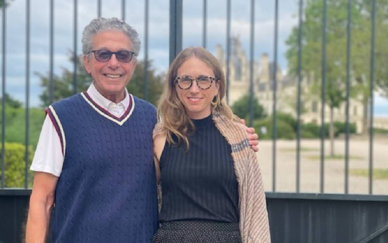 A father and daughter smiling together in front of a landmark. Next Avenue