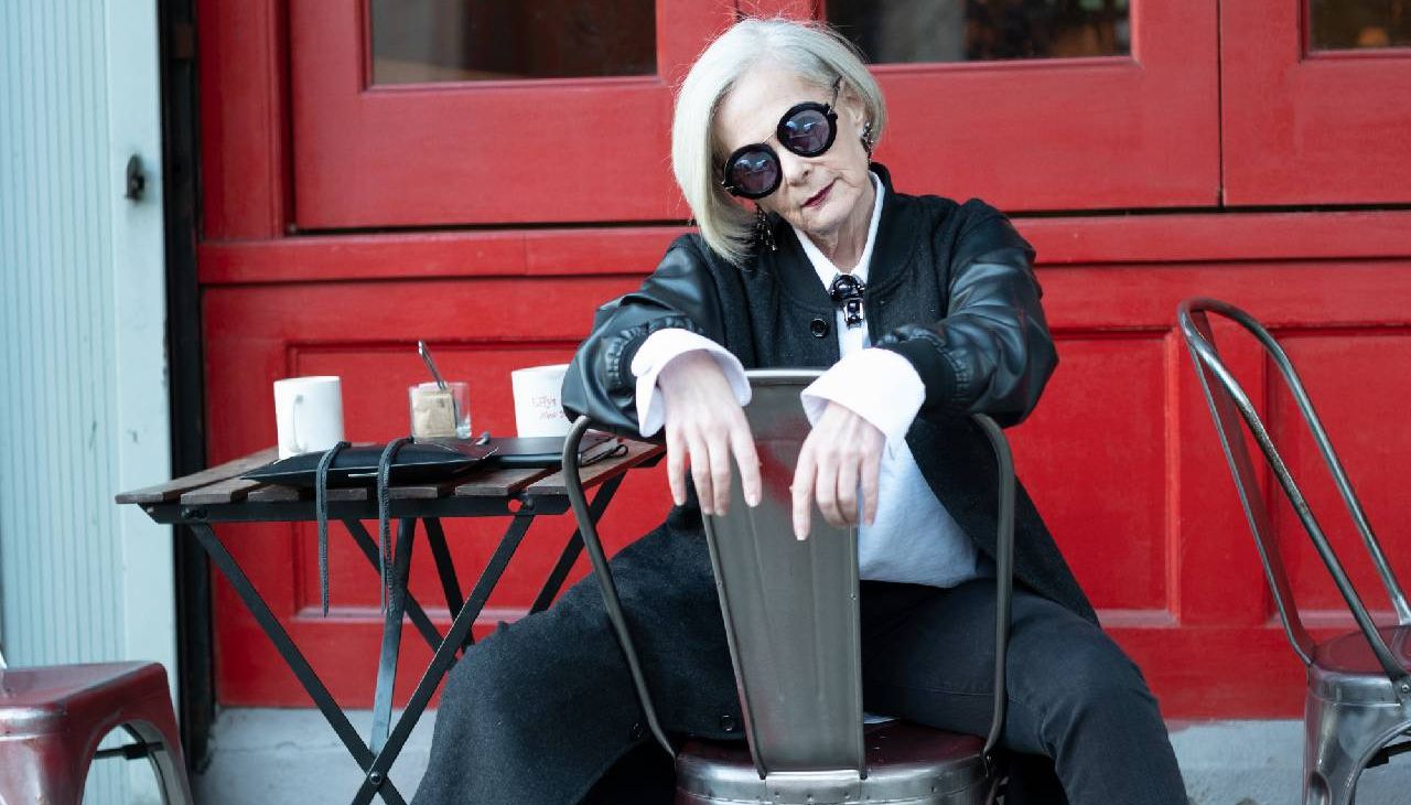 A fashionable older woman posing outside of a cafe. Next Avenue, Lyn Slater