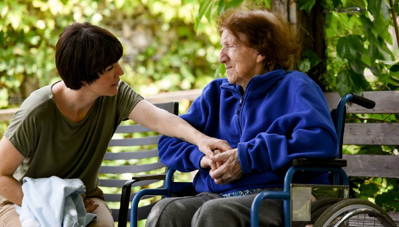 A family caregiver helping her loved one while sitting outside. Next Avenue, caregivers