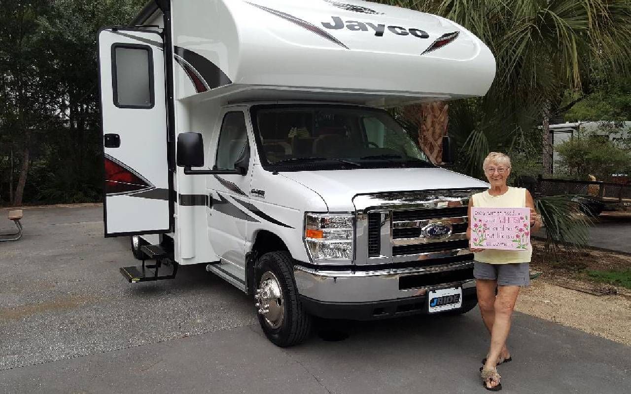A woman smiling and standing in front of her RV. Next Avenue, RV