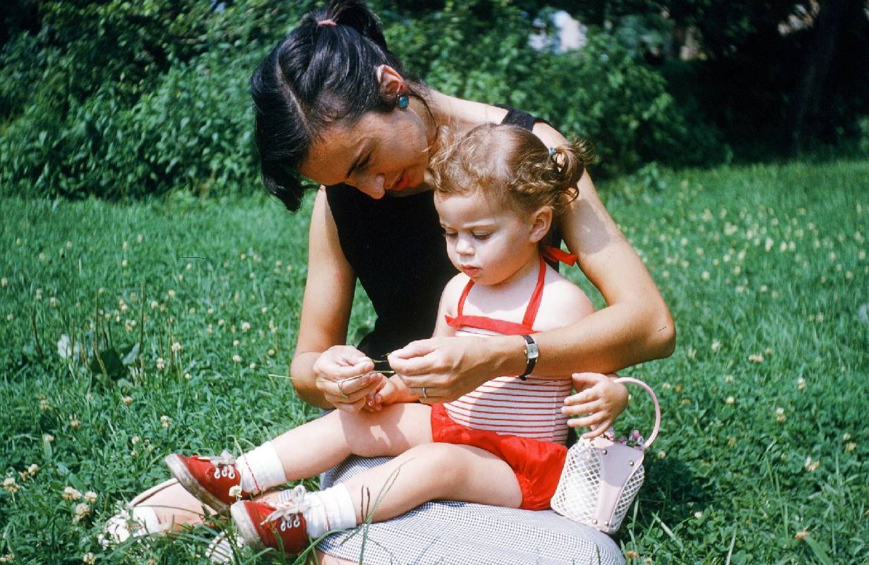 A mother sitting with her young daughter in the grass. Next Avenue, mother, relationship, estrangement, estranged from mom