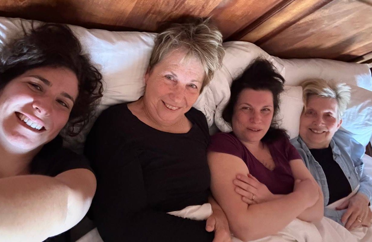 Four sisters laying in bed together. Next Avenue, this is 70
