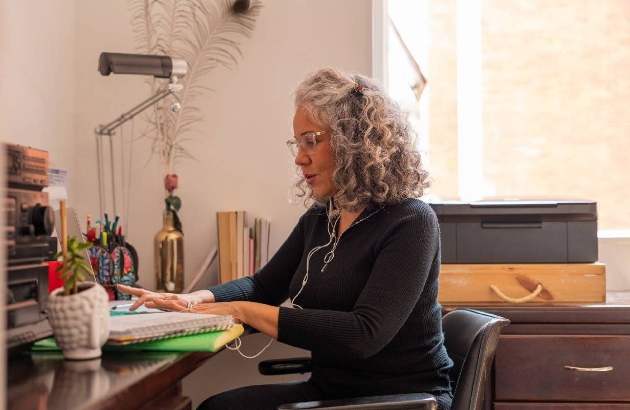 A middle aged woman in her home office taking a look at her finances. Next Avenue, afford a long life