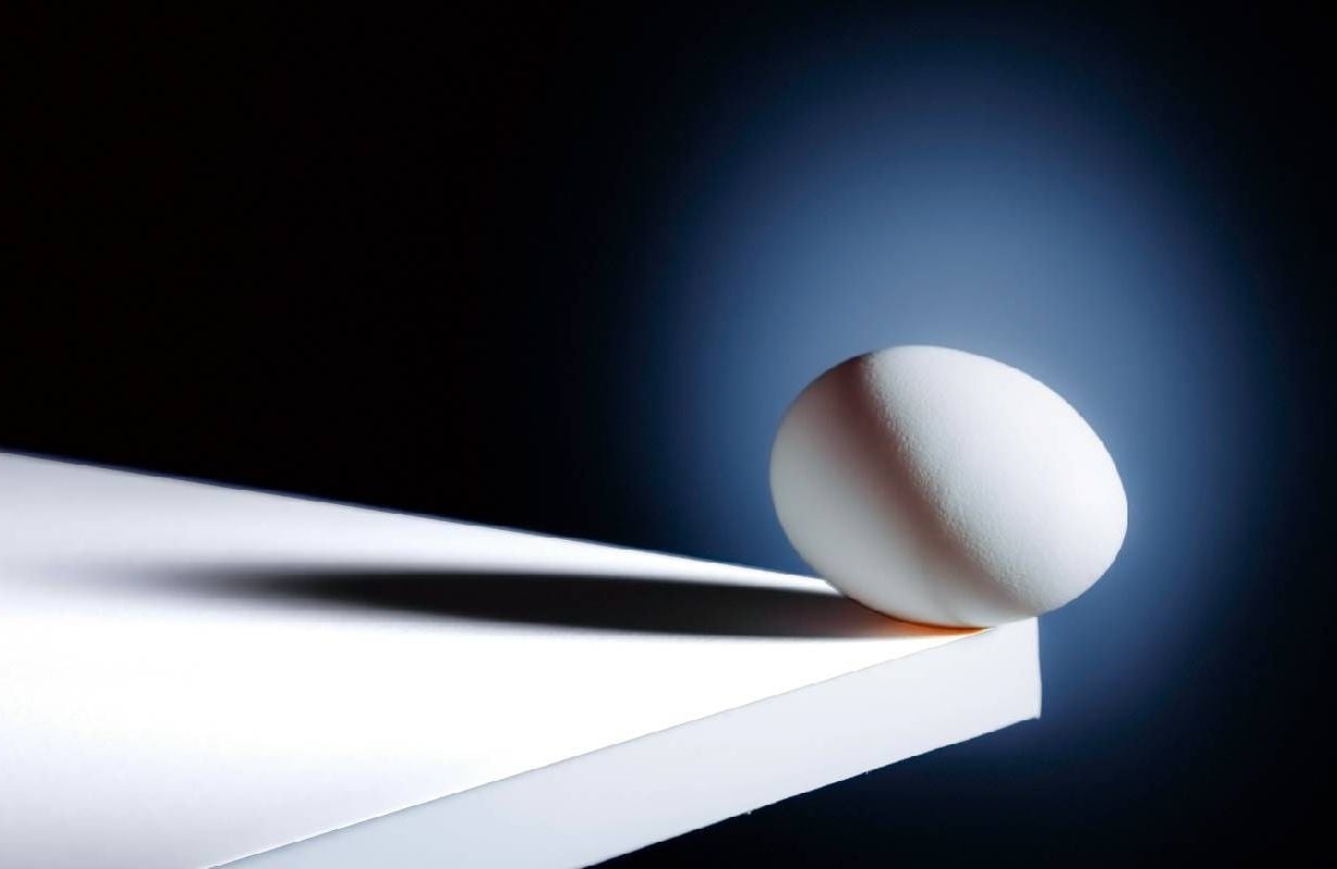 An egg balancing at the edge of a table. Next Avenue, annuity, retirement