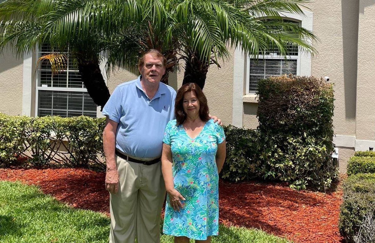 Two people standing outside of their home. Next Avenue, climate change, retirement