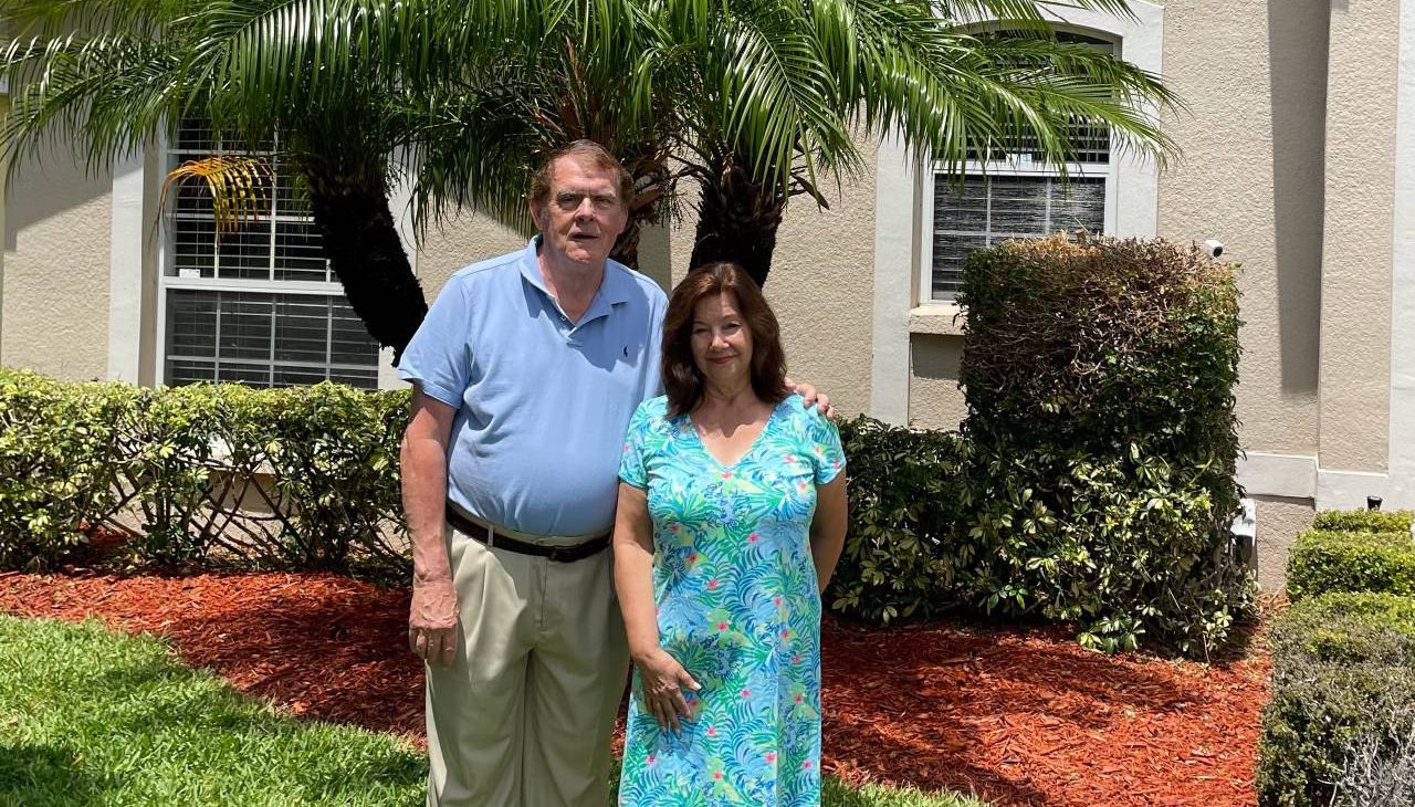 Two people standing outside of their home. Next Avenue, climate change, retirement