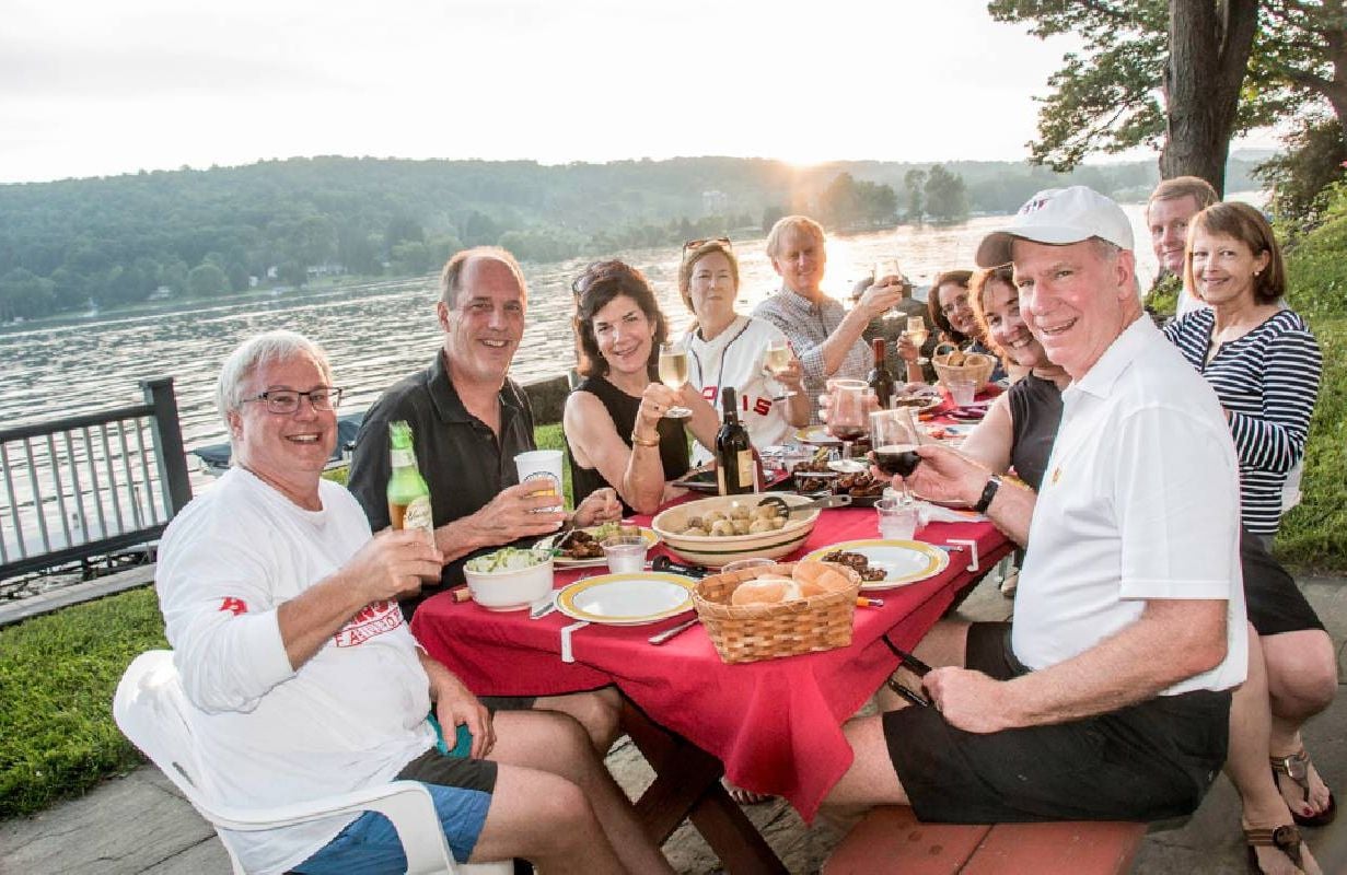 A group of people smiling around a picnic table. Next Avenue,