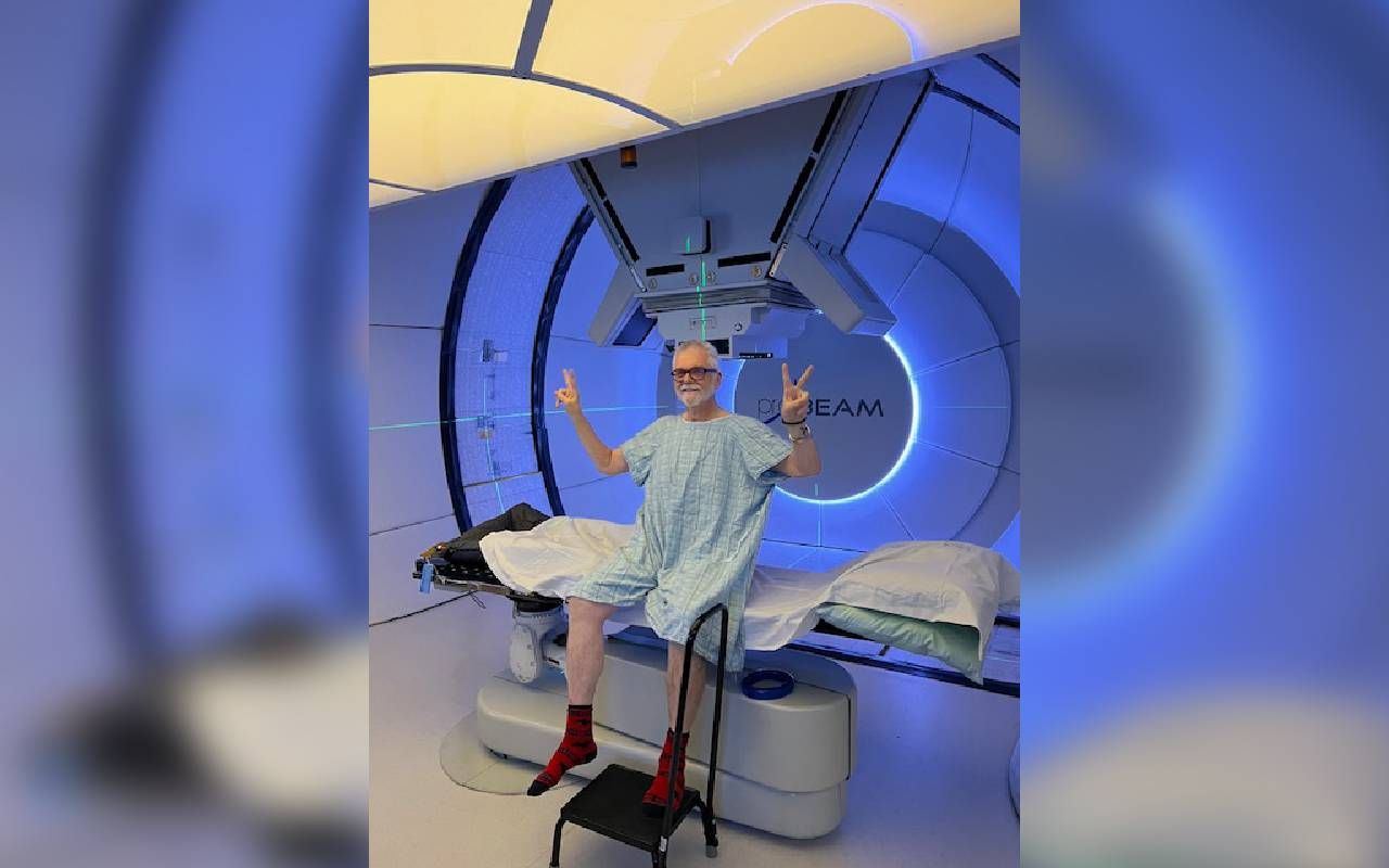 A man sitting up in front of a large proton therapy machine. Next Avenue, prostate cancer