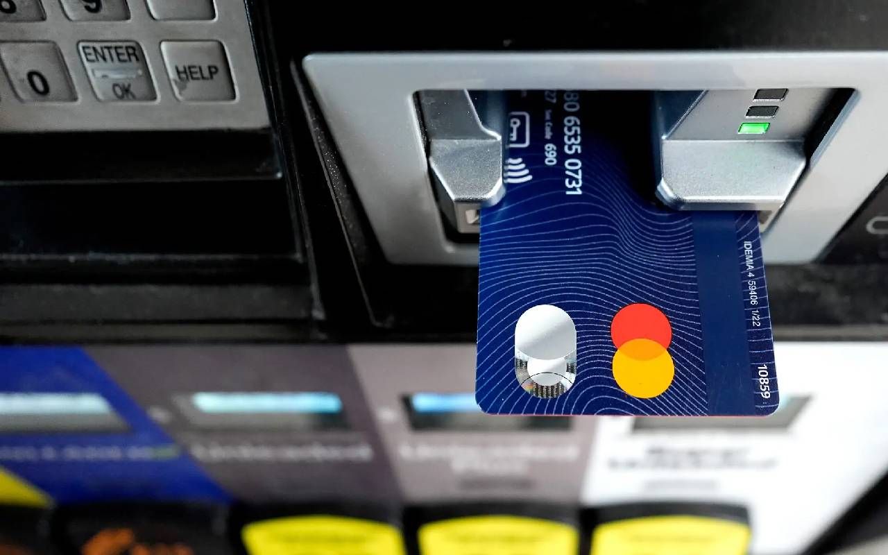 Close up of a credit card being processed at a gas pump. Next Avenue, debt free