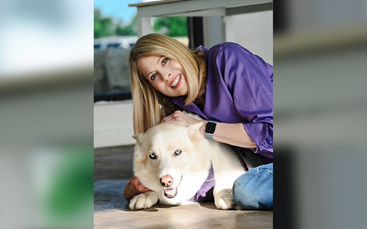 A woman smiling with her service dog. Next Avenue, bilingual, multilingual