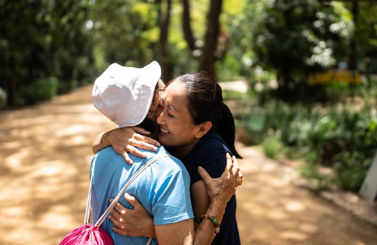 A mother and adult daughter embracing outside. Next Avenue, not having kids