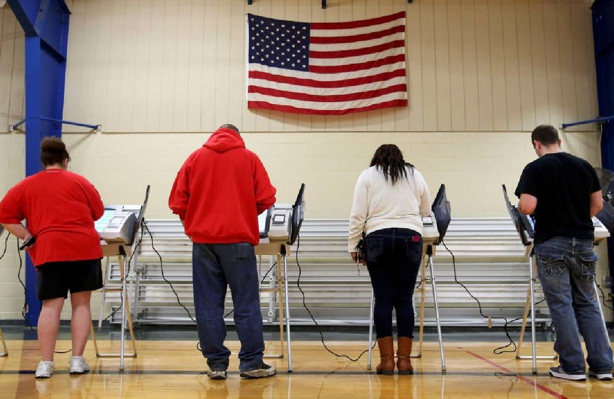 Voters filling out ballots in a voting booth. Next Avenue, cognitive decline, alzheimer's, voting