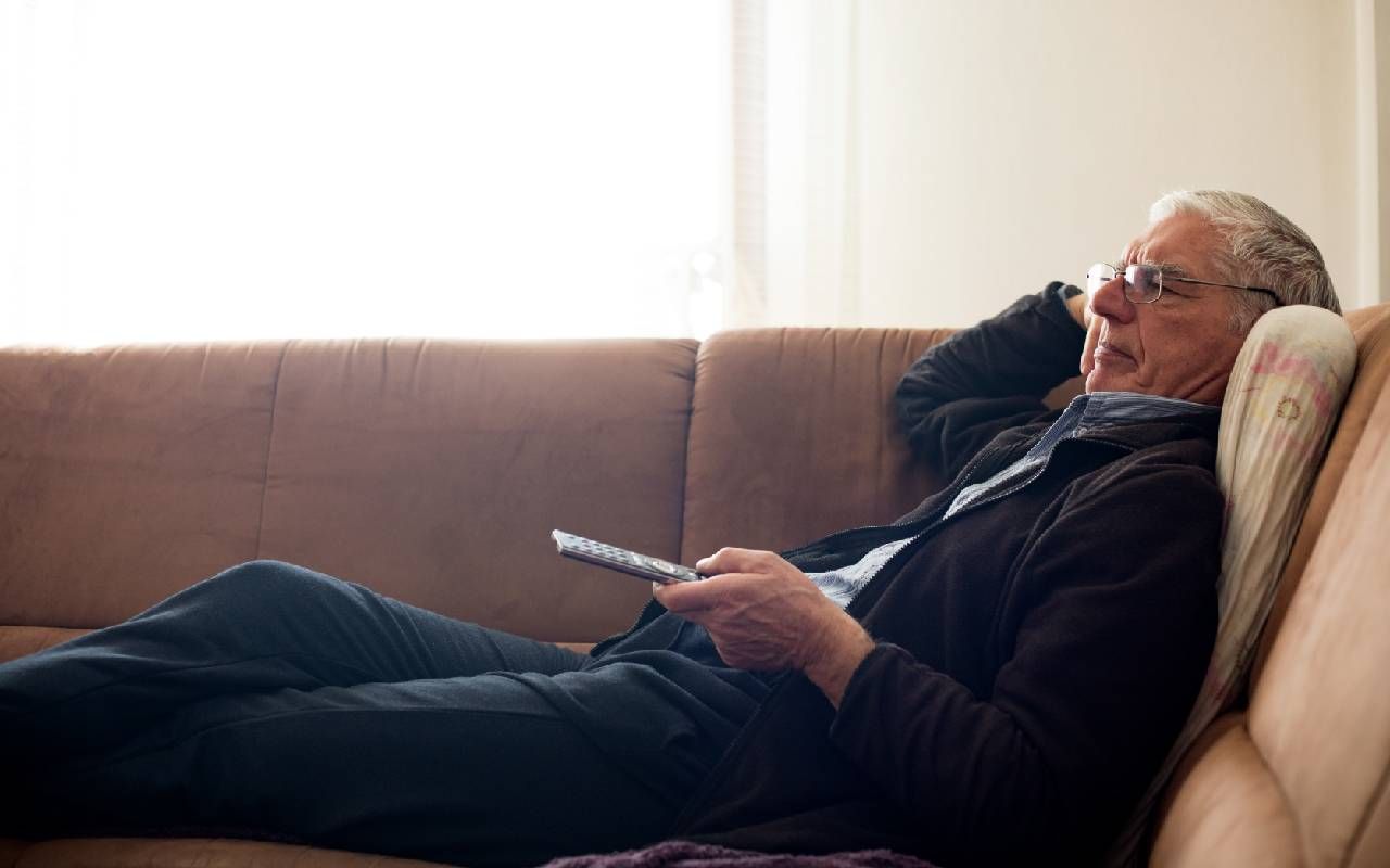 An older adult laying down watching TV. Next Avenue