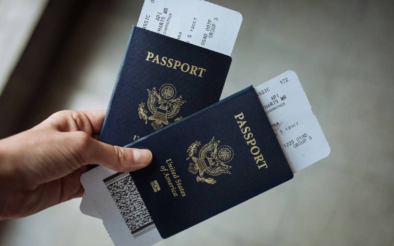 A person holding two passports and boarding passes. Next Avenue, renew passport