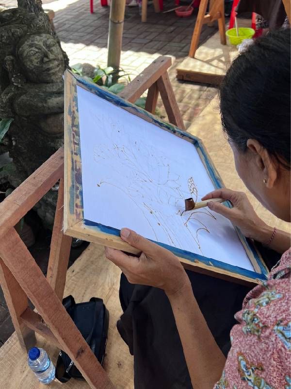 Drawing wax resist lines using a tjanting tool. Next Avenue, Batik