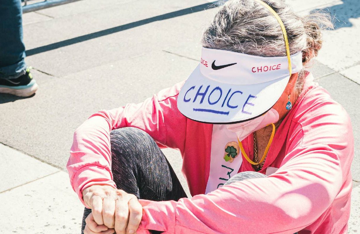 A woman sitting on the ground after the women's march. Next Avenue