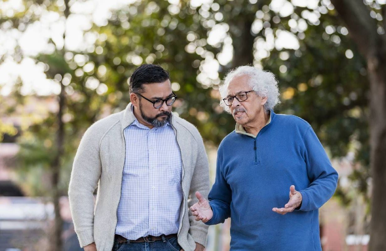 An older man talking to a younger person. Next Avenue