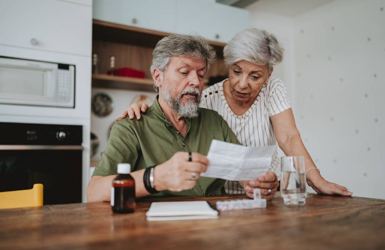 A couple looking at a bill for their prescription medication. Next Avenue, medicare costs