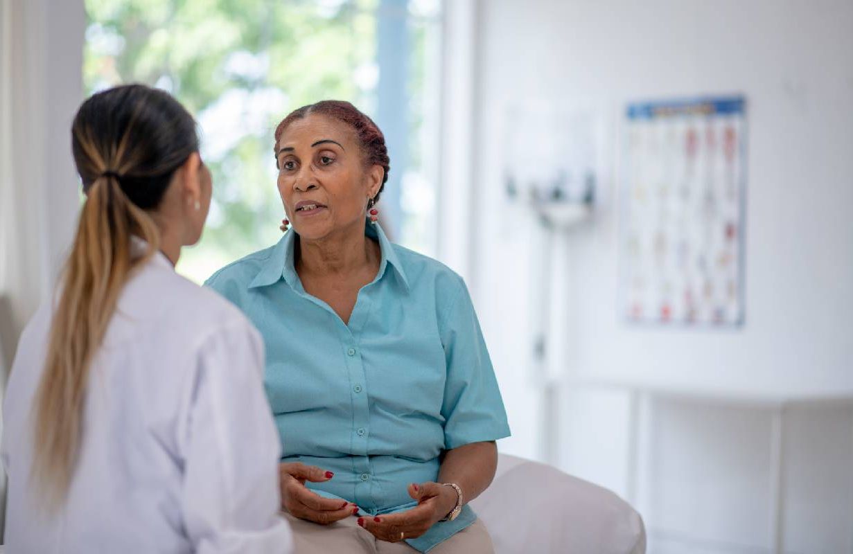 A woman talking to her doctor. Next Avenue, UTI symptoms, older adults