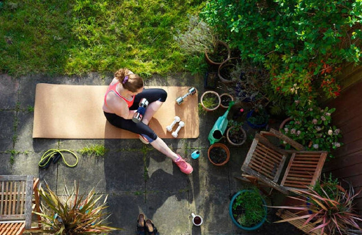 A woman working out in her backyard. Next Avenue, workout, high intensity