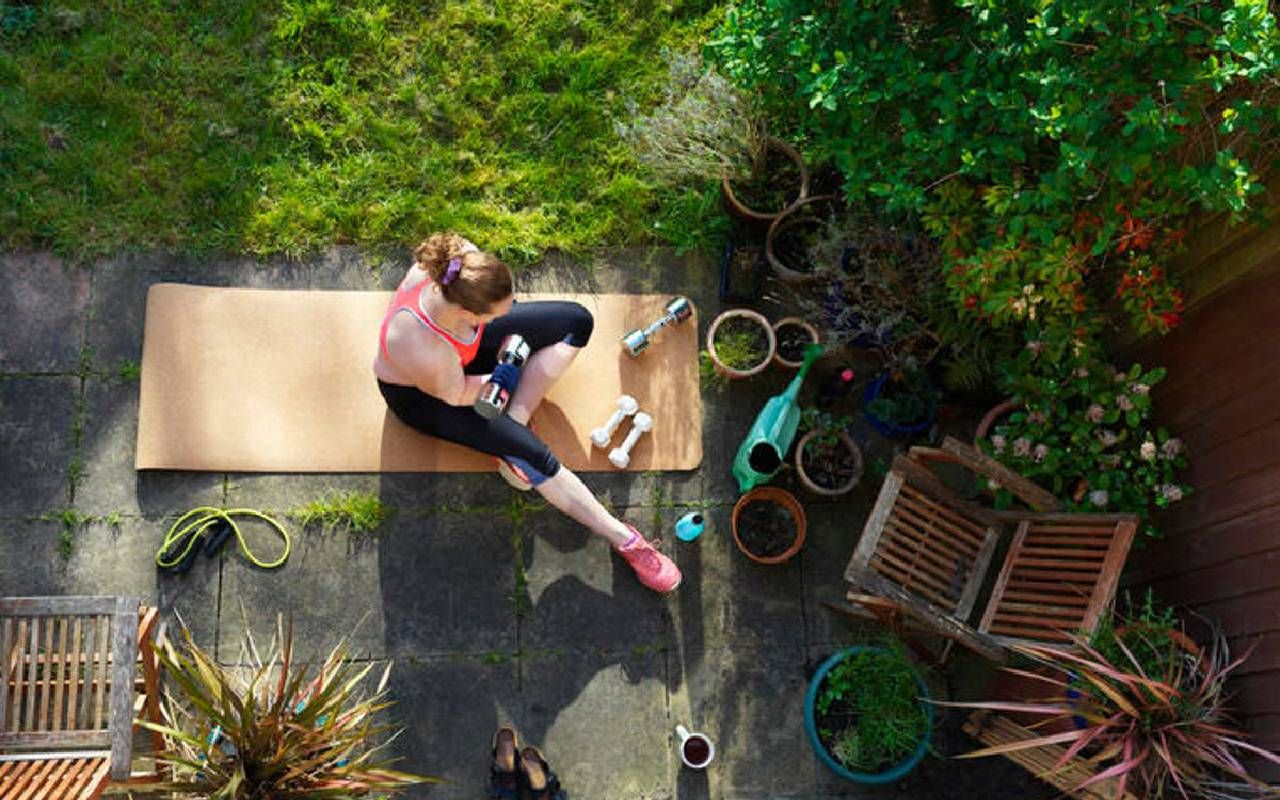 A woman working out in her backyard. Next Avenue, workout, high intensity