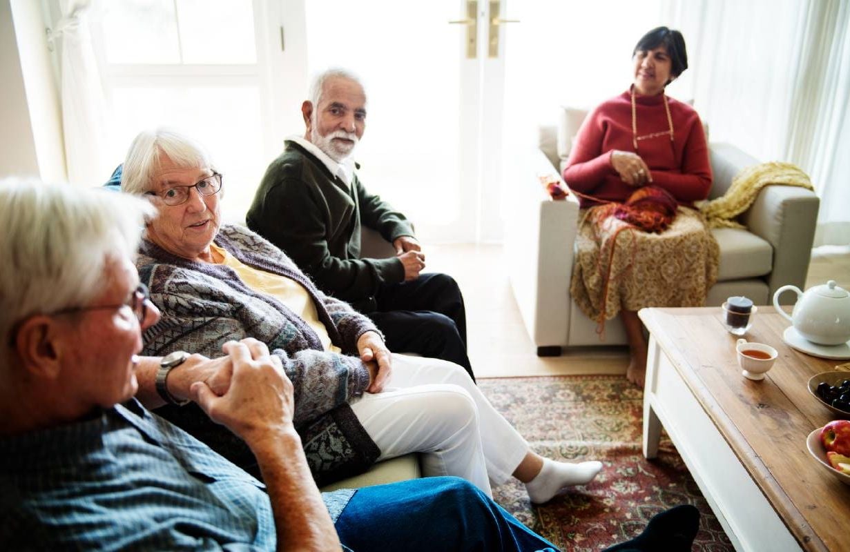 Four older adults gathering together to have a discussion. Next Avenue, cohousing