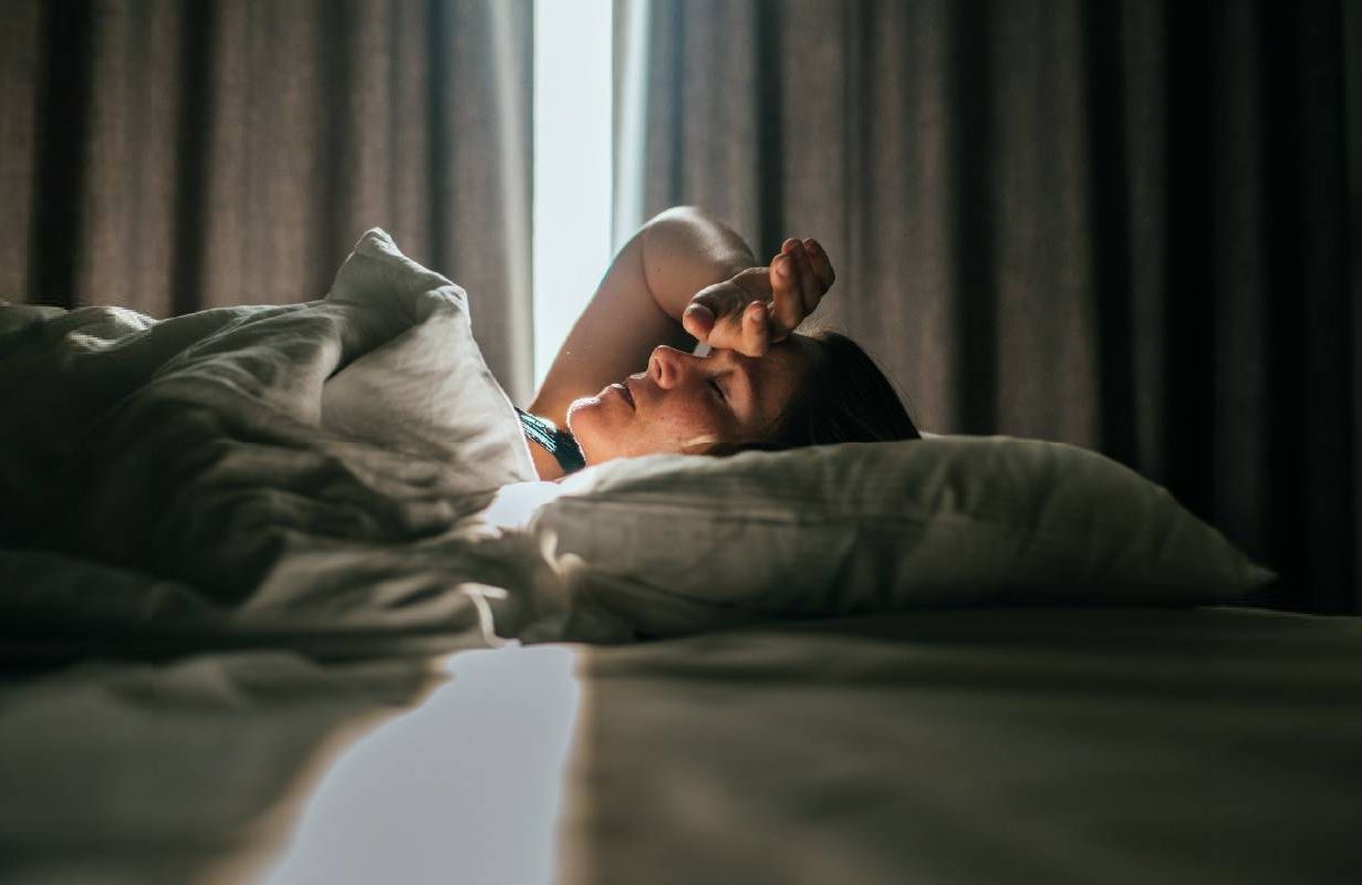 A person waking up in their bed. Next Avenue, cancer fatigue