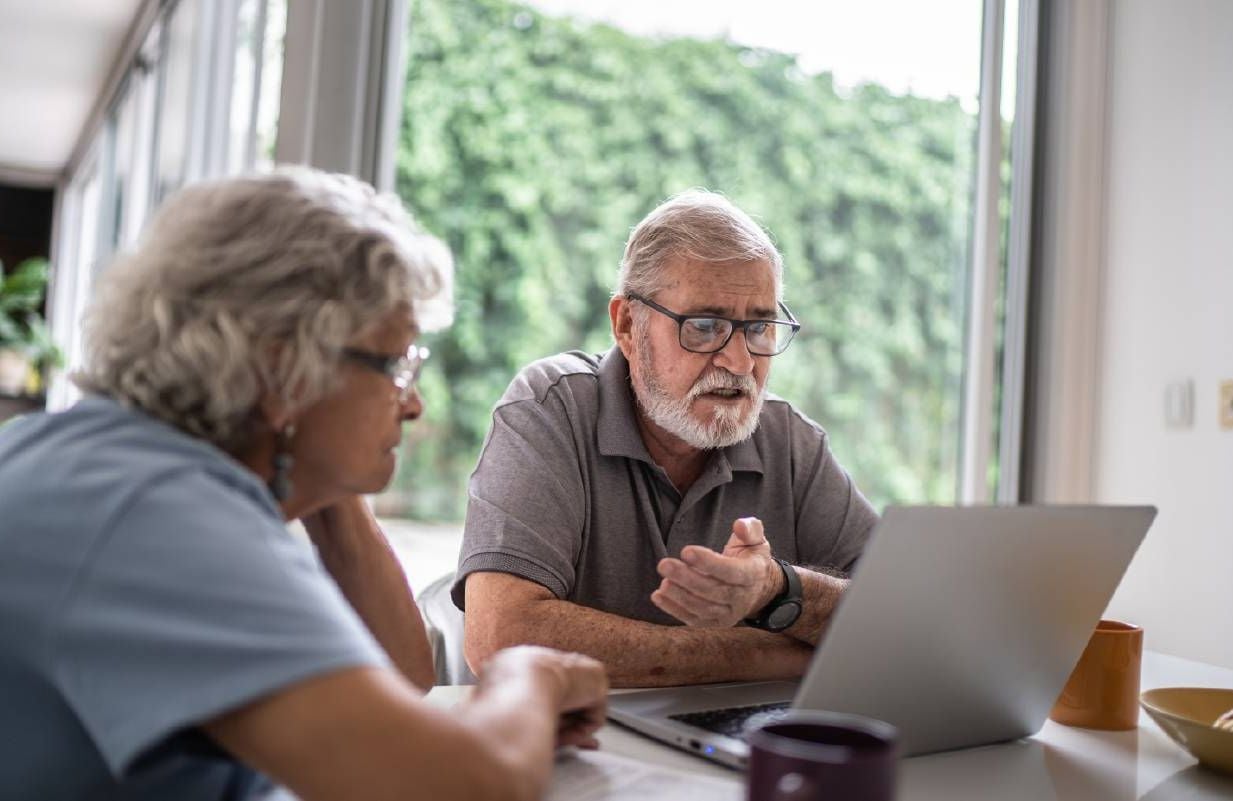 A couple looking at their online banking account. Next Avenue, financial fraud