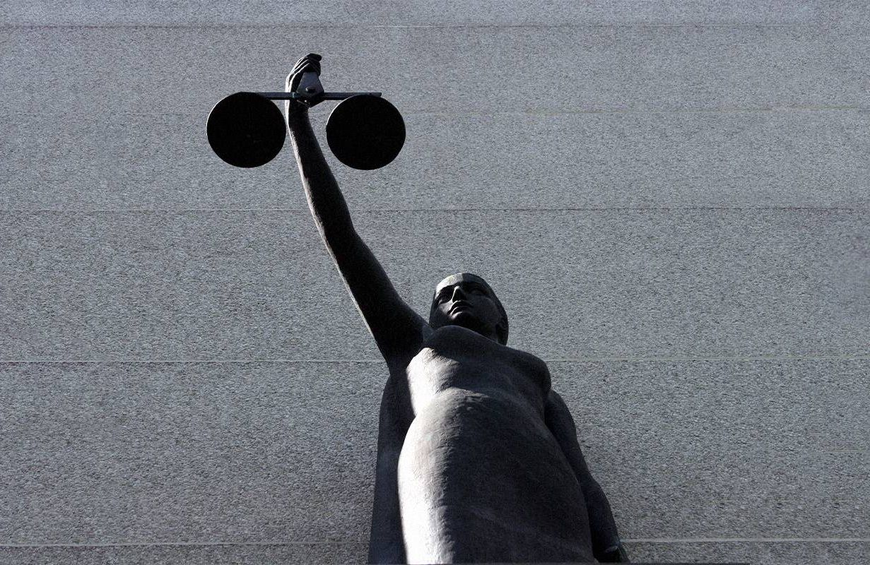 A black and white photo of a statue holding up a set of scales. Next Avenue, integrity, justice