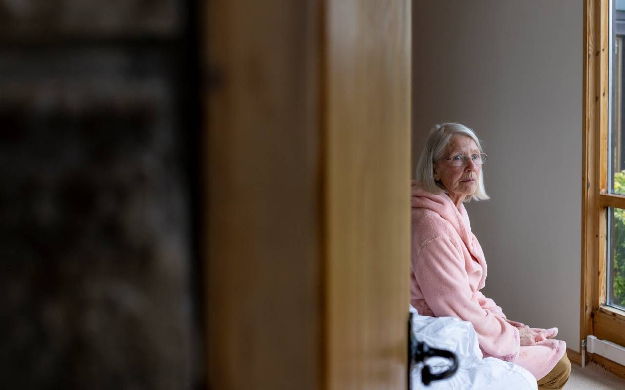 An older woman sitting on the edge of a bed. Next Avenue, longevity, health
