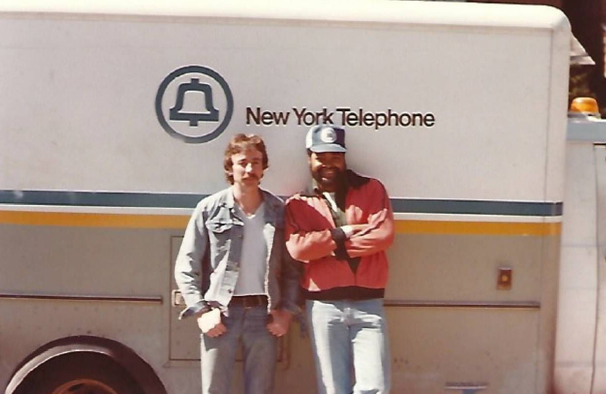 Two people standing in front of an old New York Bell truck. Next Avenue, post-retirement job
