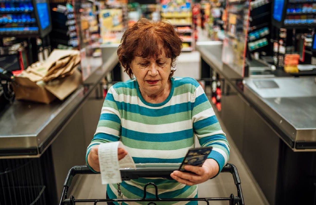 A woman reviewing her grocery bill. Next Avenue, protect against inflation