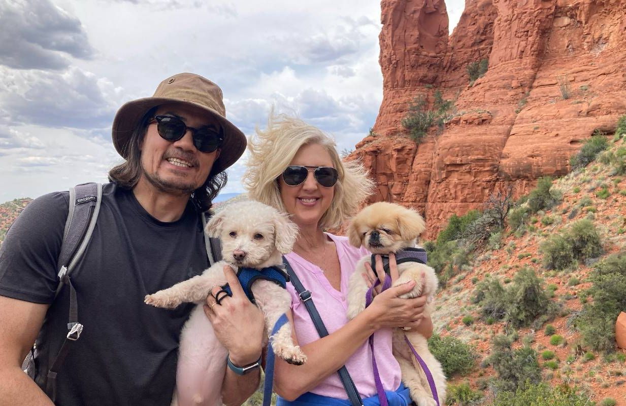 A couple smiling with their dogs during a vacation. Next Avenue, traveling with pets