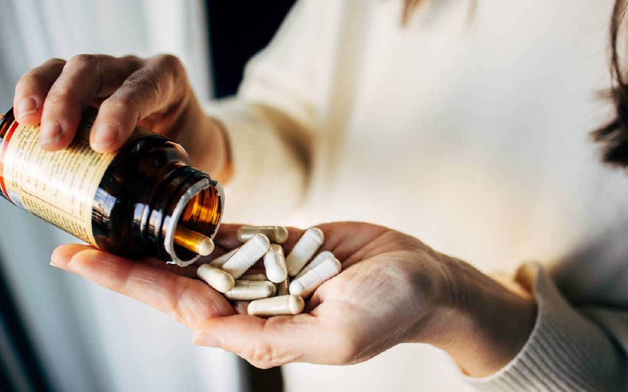 A person holding multiple vitamins. Next Avenue, health benefits