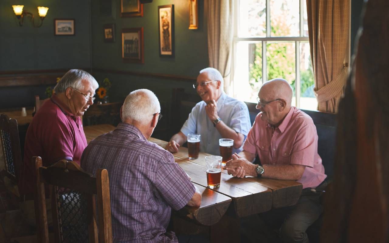 Group of older men sitting together in a bar. Next Avenue, fantasy baseball