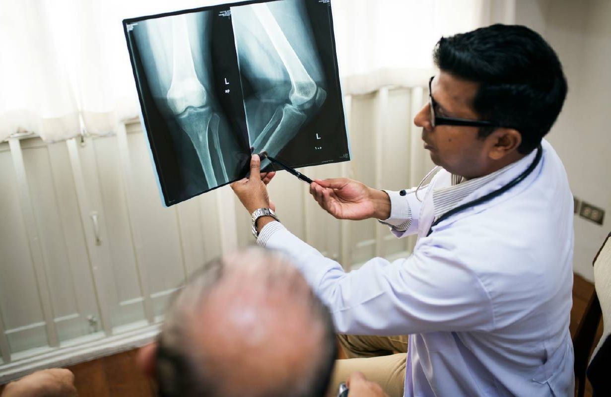 A doctor talking to patient about knee replacement surgery. Next Avenue
