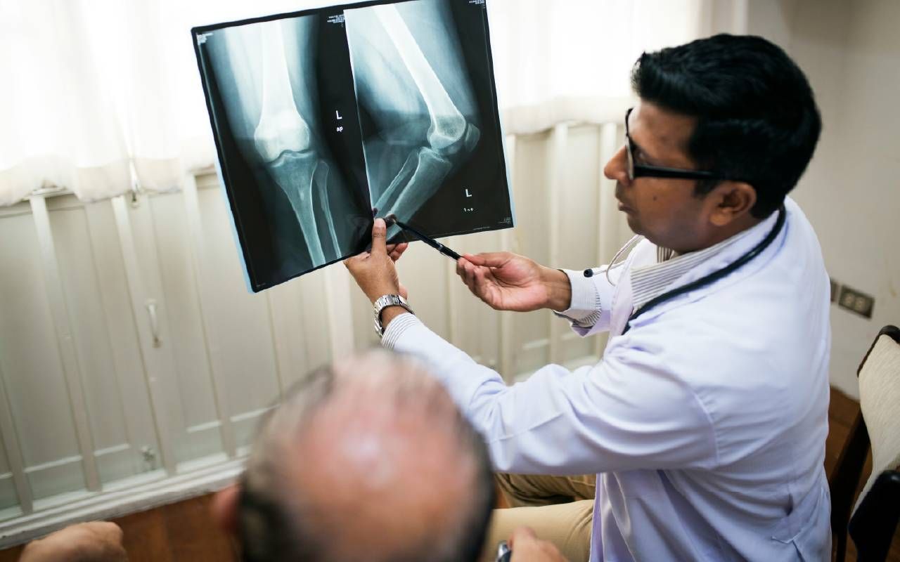 A doctor talking to patient about knee replacement surgery. Next Avenue