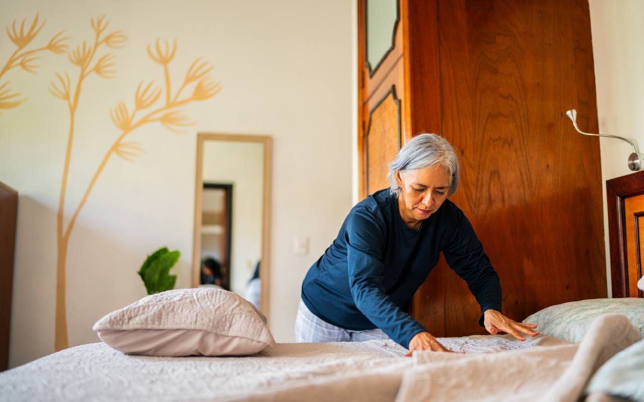 A woman making her bed in the morning. Next Avenue, pink noise, deep sleep