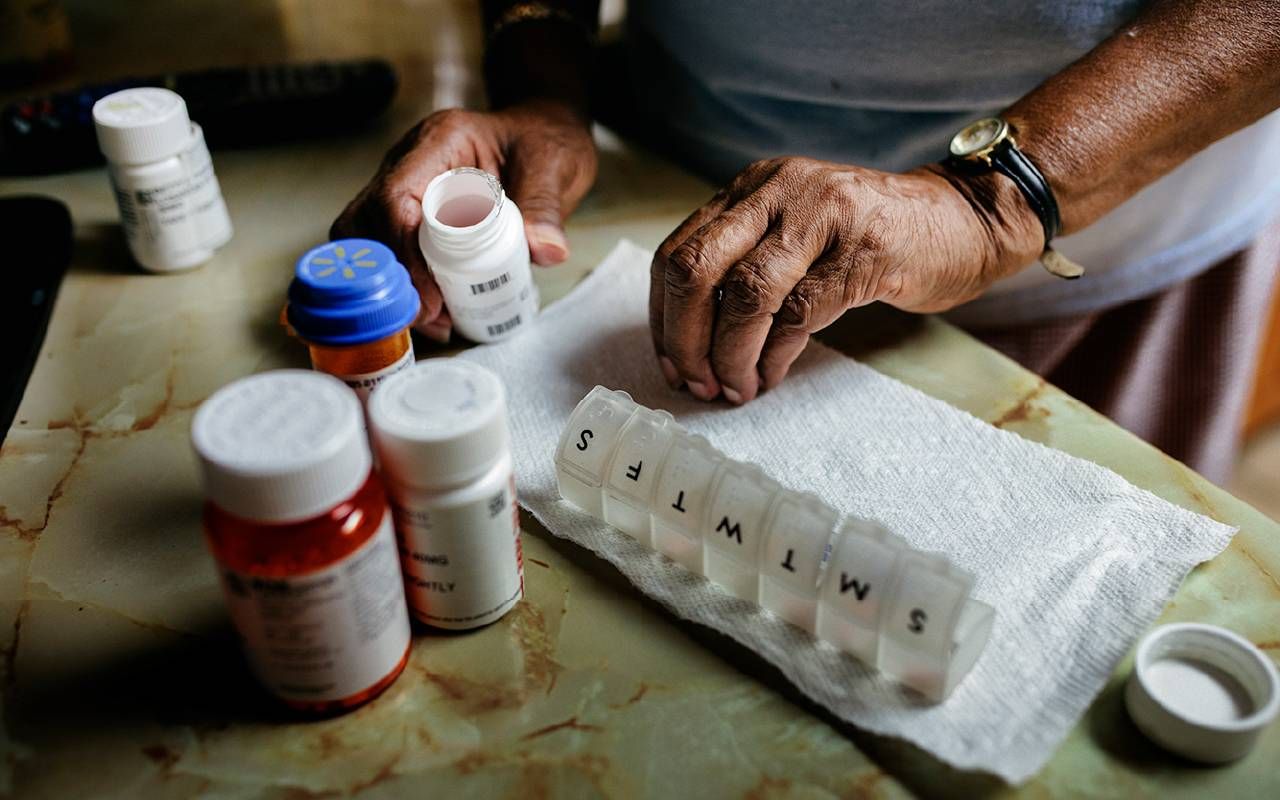 A person putting their prescription medication in a pill box. Next Avenue, Tariffs on Prescription Drugs