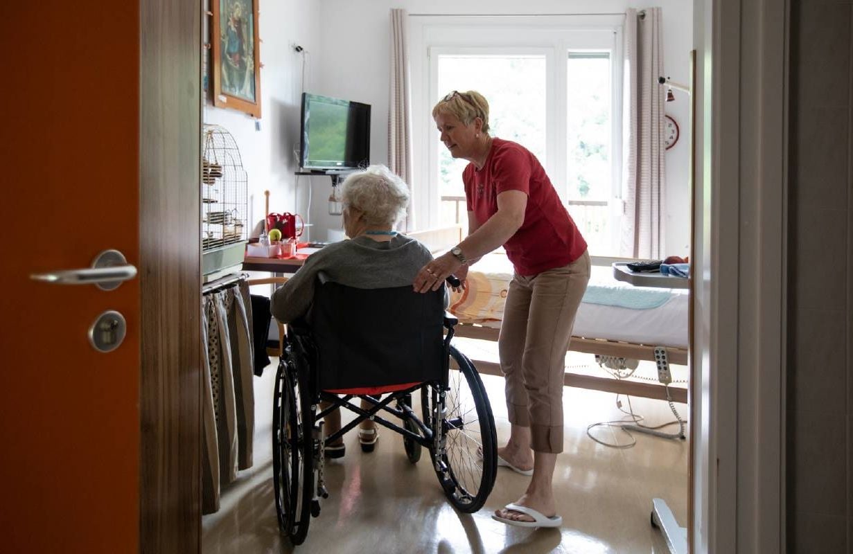 A caregiver helping their older loved one. Next Avenue