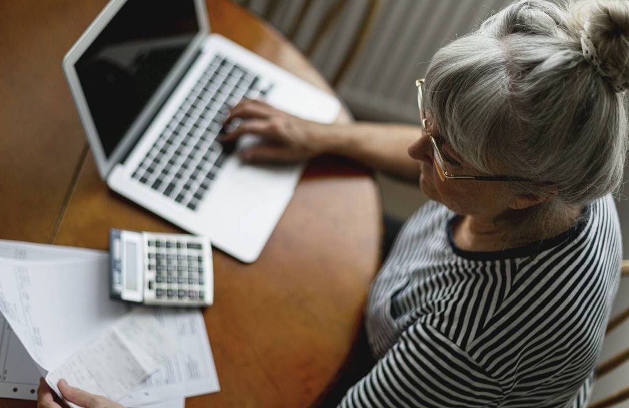 An older adult looking at her credit card bill. Next Avenue