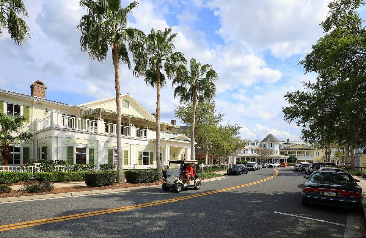 A person riding in a golf carf through a retirement community. Next Avenue