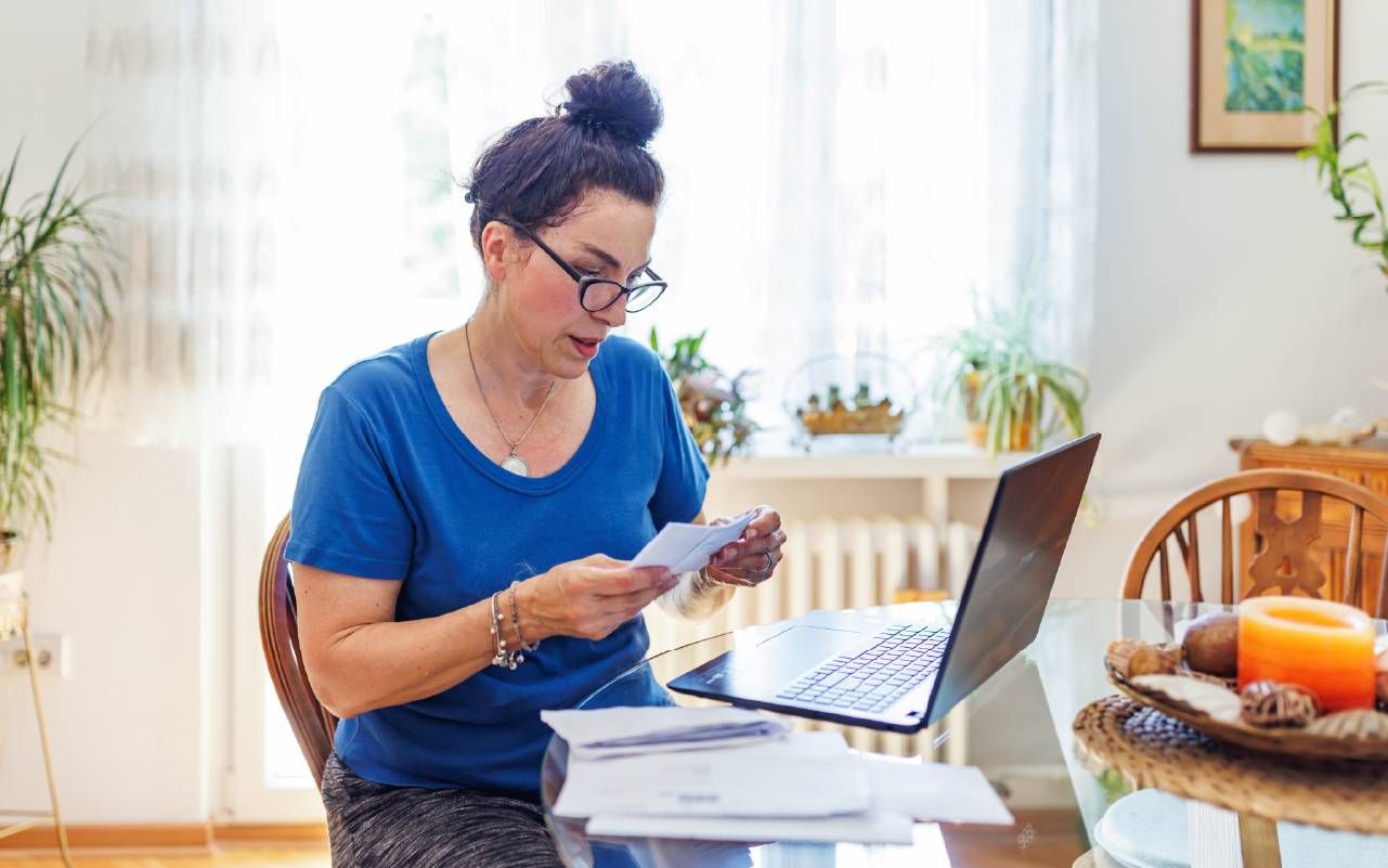 A woman looking over documents. Next Avenue, survivor benefits
