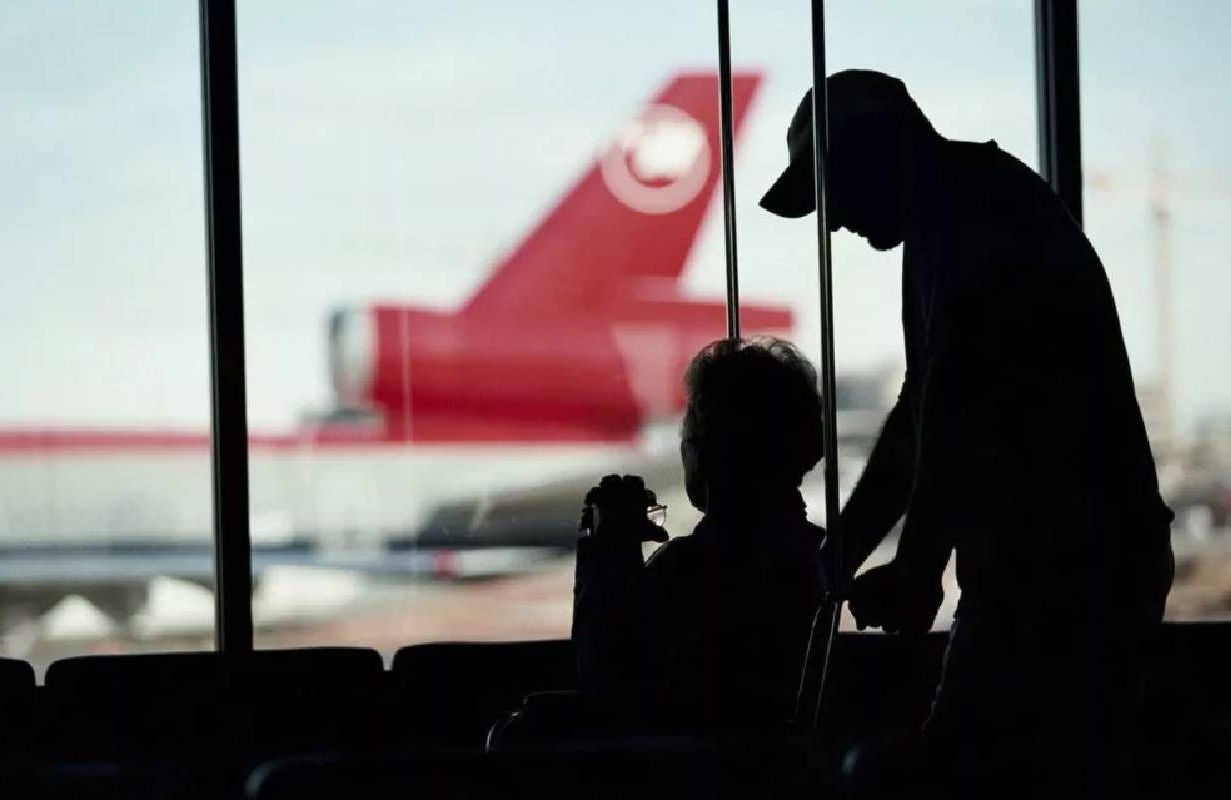 Silhouette of a person in a wheelchair and their caregiver. Next Avenue, flying with disabilities, wheelchair