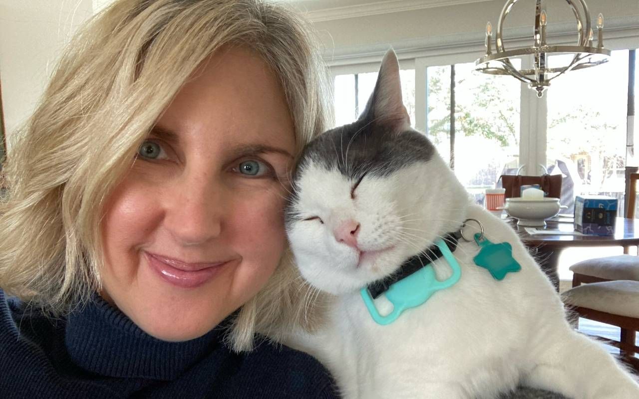 W oman smiling with a cat. Next Avenue, pet sitting