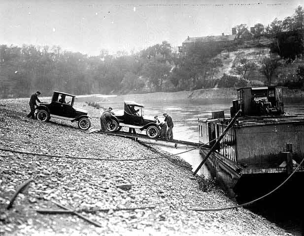 Ford cars being loaded onto a barge that waits on the Mississippi River. Photo courtesy of the Minnesota Historical Society.