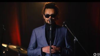 a person wearing sunglasses and holding a microphone