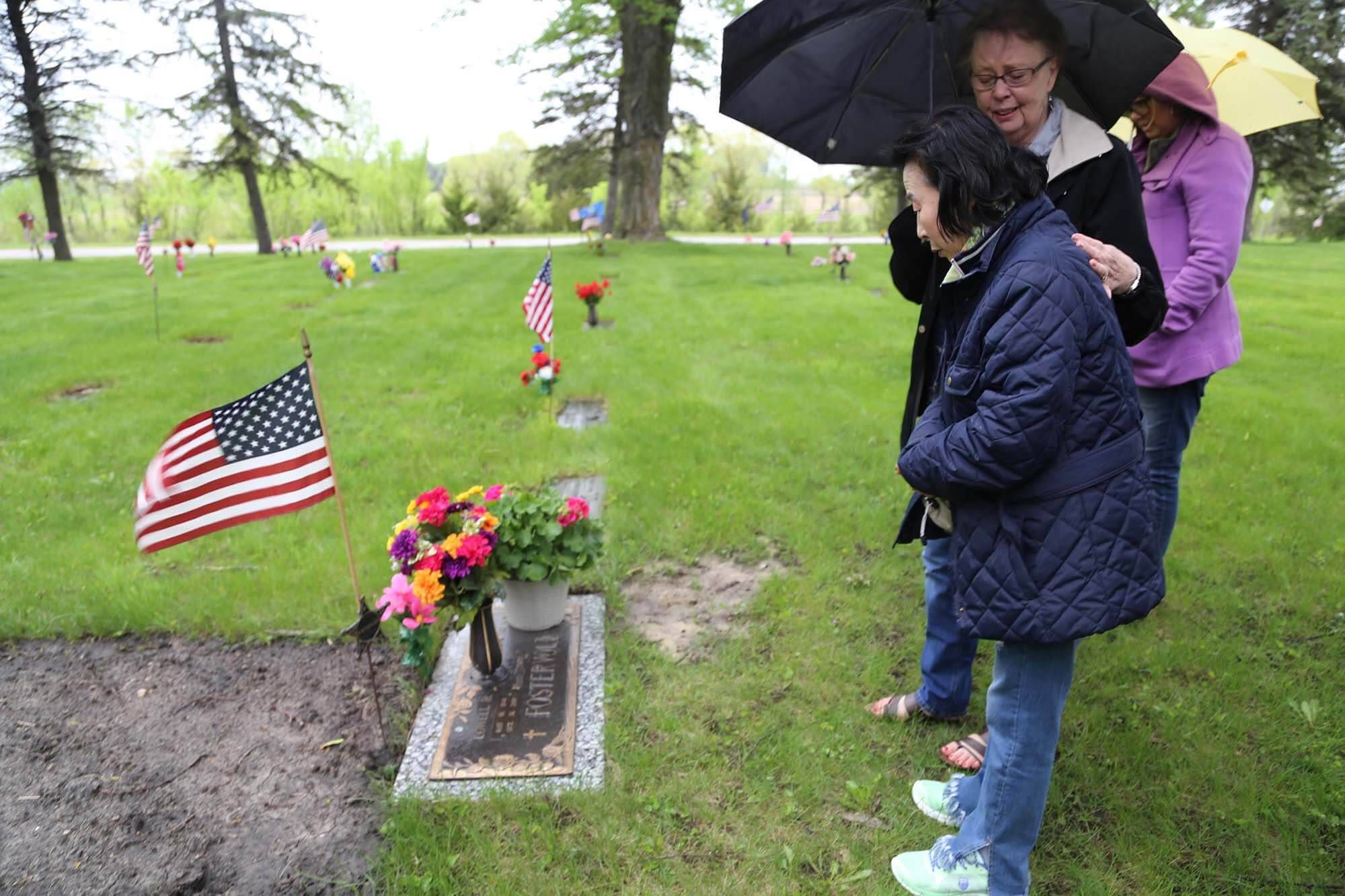 Sook-nyeon Kim pays her respects to her son's adoptive father, at his gravesite in Willmar, Minnesota.