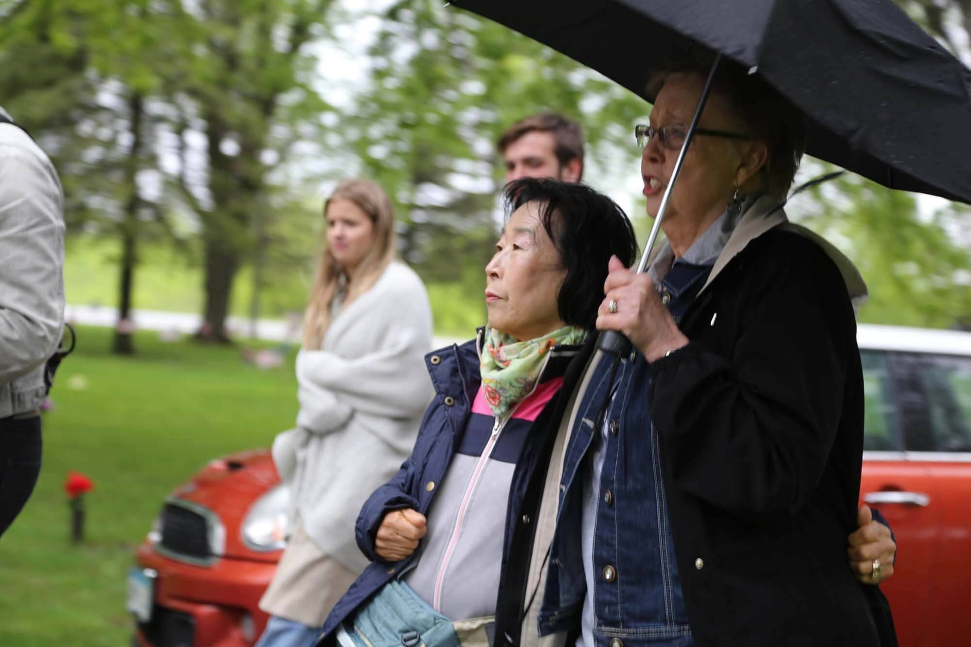 The two mothers watch the Memorial Day tribute at a cemetery in Willmar, Minn.