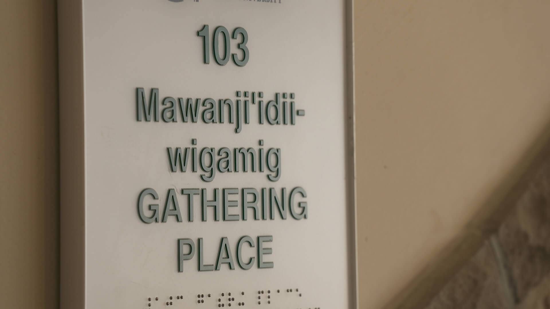 A sign that reads in both Ojibwe and English inside the American Indian Resource Center.